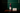 Dulenn luxury sculptural aromatherapy candle burning on a wooden console against a dark green wall — modular Buddha head candle with pink and navy wax elements