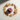 A pink ribbed silicone mold with a star-shaped cavity, styled in a flat-lay arrangement with dried orange slices, cinnamon sticks, and white flowers on a textured off-white background.